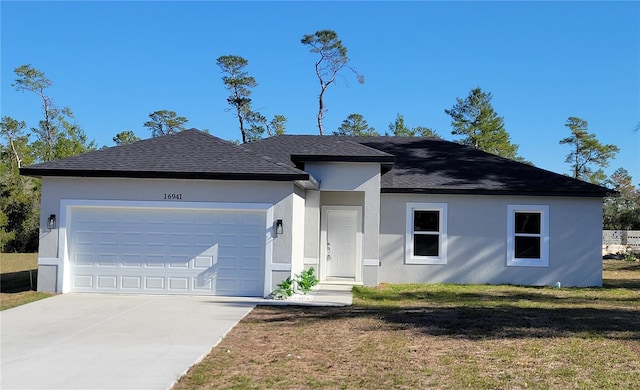 16941 SW 30th Avenue Rd SW, Ocala, FL 34473 - view of front of house with a front yard, a shingled roof, a garage, stucco siding, and driveway
