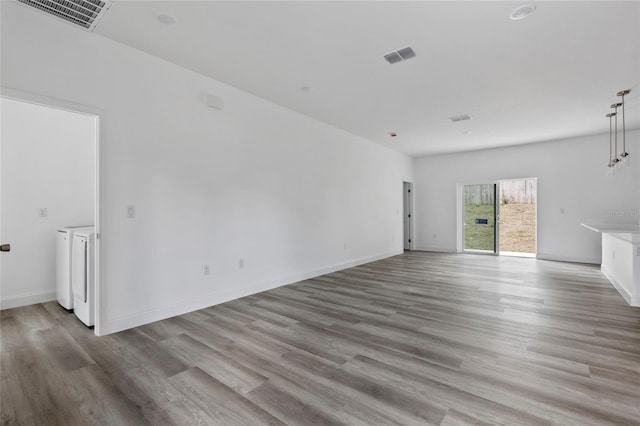 16941 SW 30th Avenue Rd SW, Ocala, FL 34473 - unfurnished living room with visible vents, baseboards, washing machine and clothes dryer, and wood finished floors