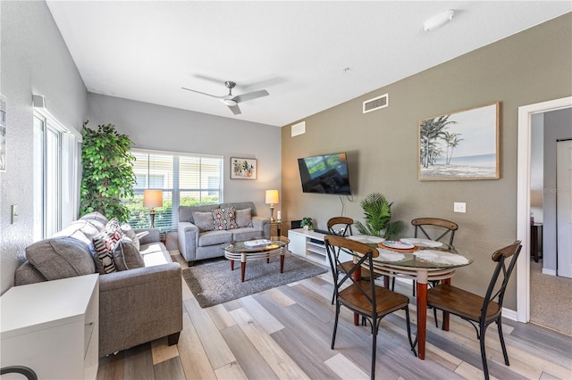 living room with ceiling fan and light hardwood / wood-style flooring