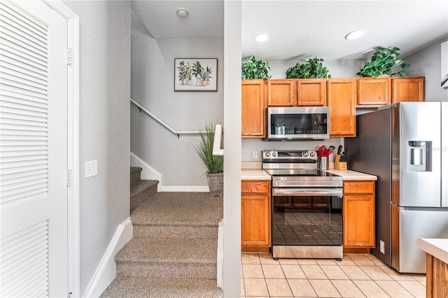 kitchen with light tile patterned flooring and appliances with stainless steel finishes