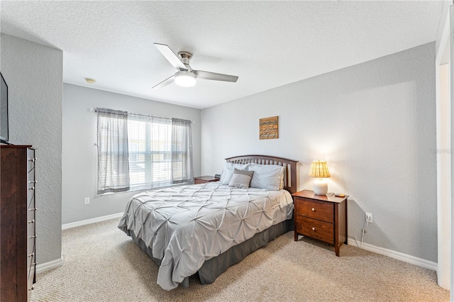 bedroom featuring a textured ceiling, ceiling fan, and light colored carpet