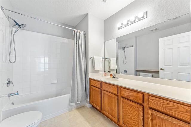 full bathroom featuring shower / bath combo with shower curtain, a textured ceiling, vanity, and toilet