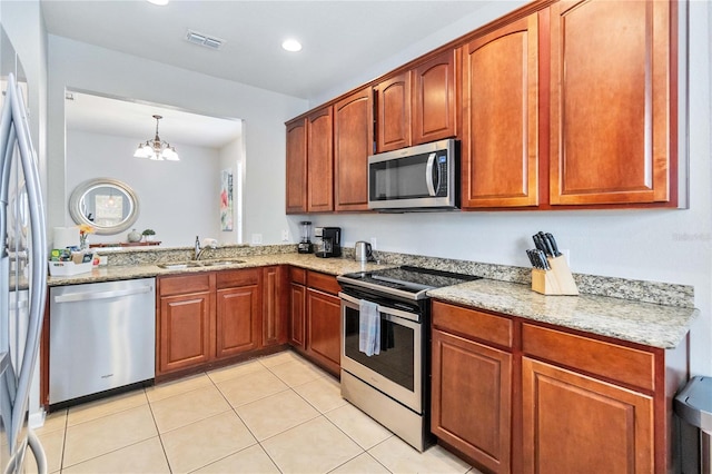 kitchen with a chandelier, decorative light fixtures, light tile patterned floors, appliances with stainless steel finishes, and sink