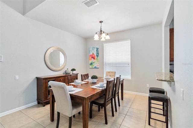 tiled dining room with a chandelier