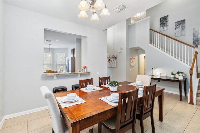 dining area featuring a notable chandelier and light tile patterned flooring