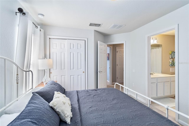 bedroom featuring sink, connected bathroom, a closet, and multiple windows