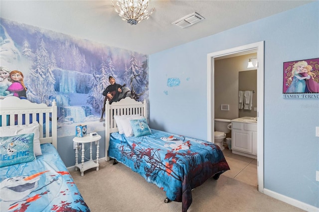 carpeted bedroom featuring ensuite bathroom and a notable chandelier