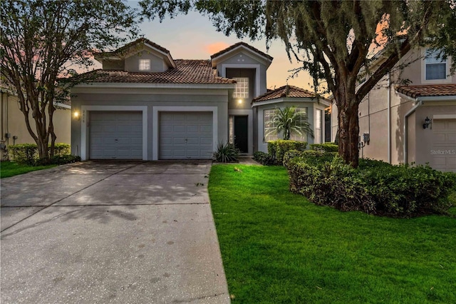 mediterranean / spanish-style home with a yard and a garage