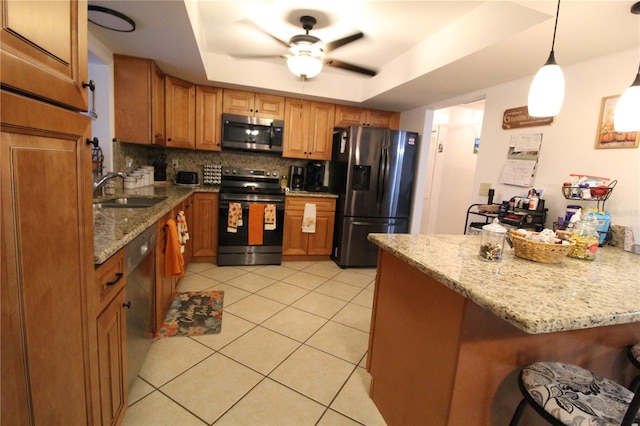 kitchen with sink, hanging light fixtures, decorative backsplash, a raised ceiling, and appliances with stainless steel finishes