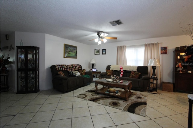 tiled living room with a textured ceiling and ceiling fan