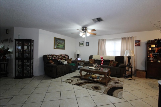 living room with ceiling fan, a textured ceiling, and light tile patterned floors