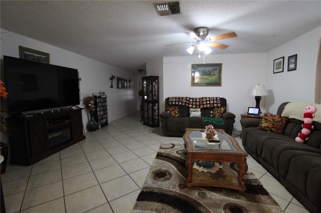 living room featuring ceiling fan, a textured ceiling, and light tile patterned floors