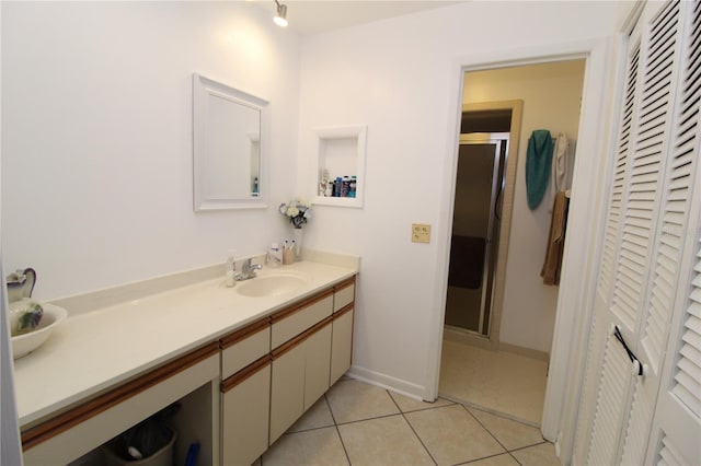 bathroom featuring a shower with door, vanity, and tile patterned floors