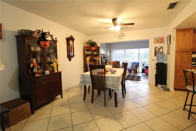 tiled dining room with ceiling fan and a textured ceiling