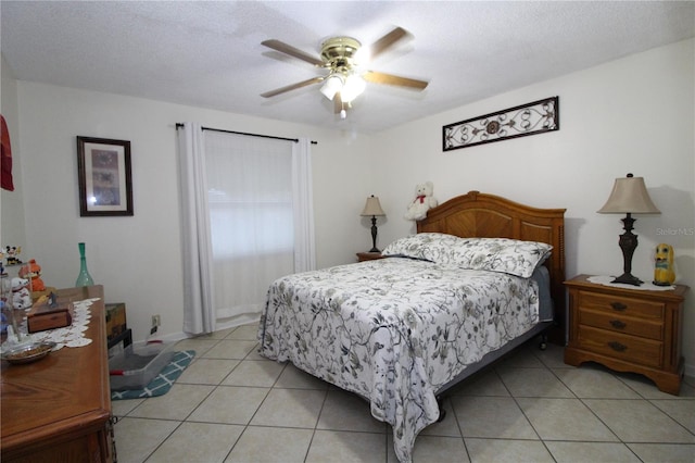 bedroom featuring a textured ceiling, light tile patterned floors, and ceiling fan