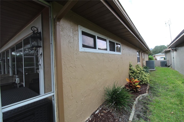 view of home's exterior featuring cooling unit and a lawn