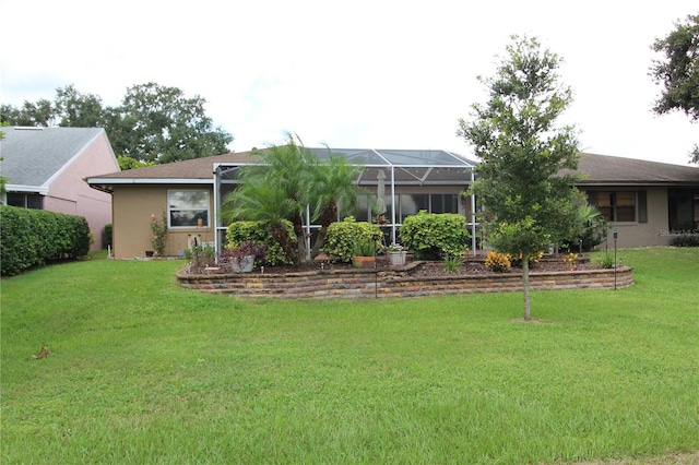 back of house with a lawn and glass enclosure