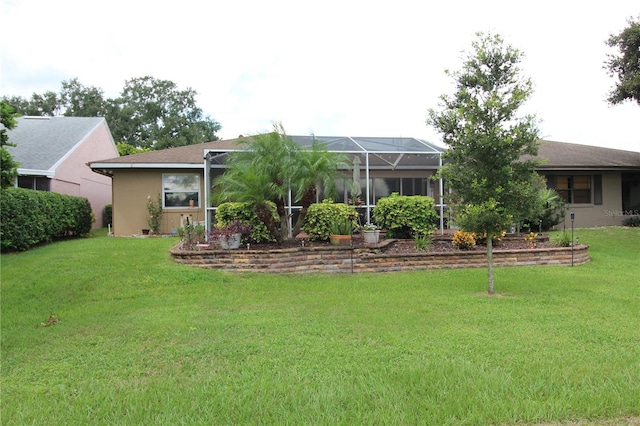 back of property with a lawn and a lanai