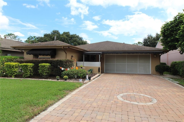 ranch-style home with a garage and a front lawn