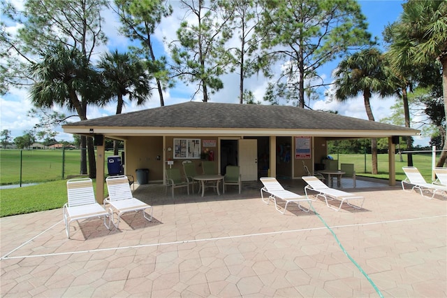 rear view of property featuring a patio and a yard