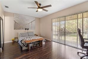 bedroom with access to exterior, ceiling fan, and dark wood-type flooring