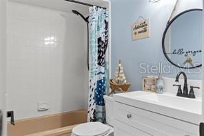 full bathroom featuring shower / bath combo with shower curtain, vanity, and toilet