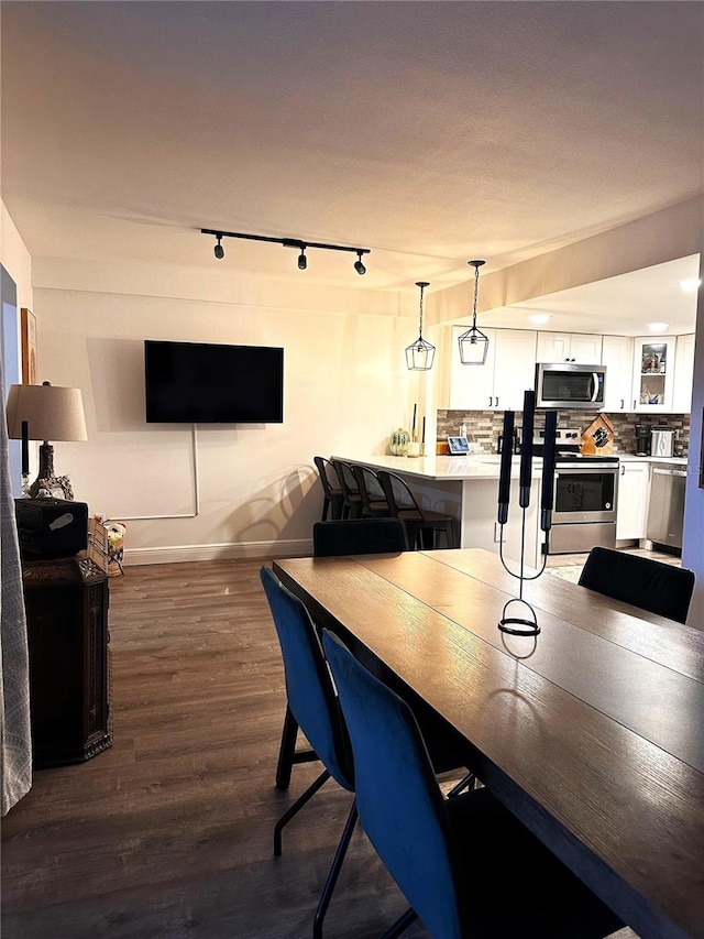 dining space featuring dark hardwood / wood-style floors and rail lighting