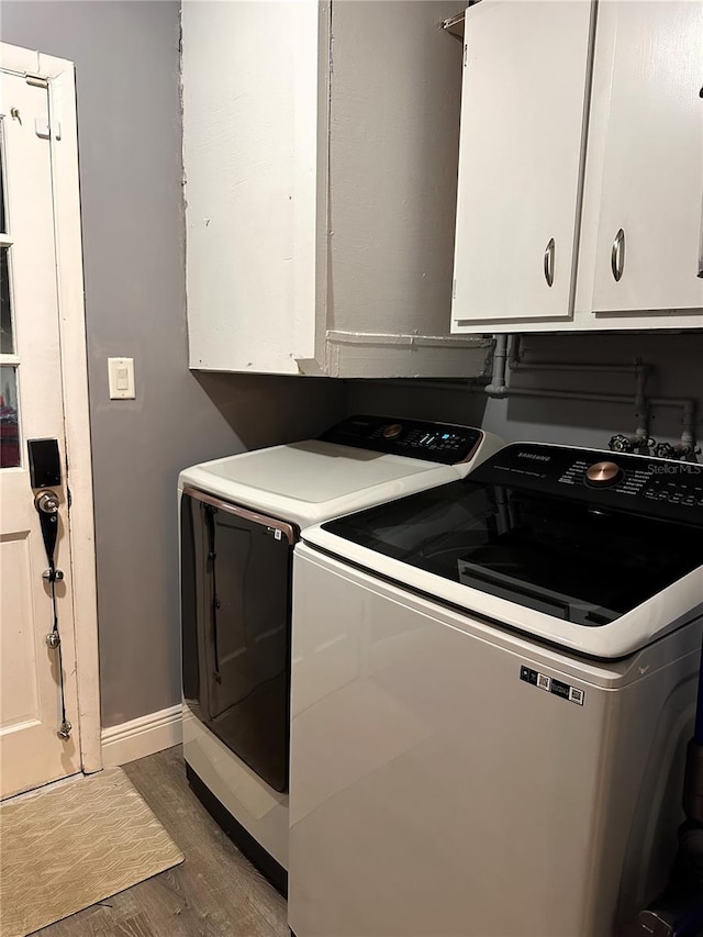 laundry room featuring separate washer and dryer, cabinets, and dark hardwood / wood-style floors