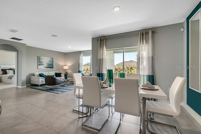 tiled dining area with a textured ceiling