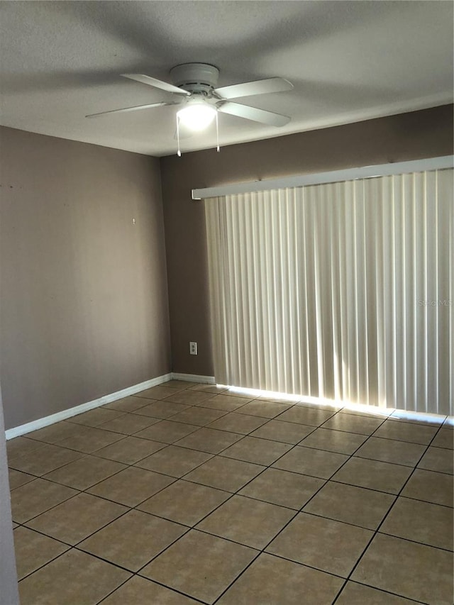 empty room with a textured ceiling, tile patterned floors, and ceiling fan