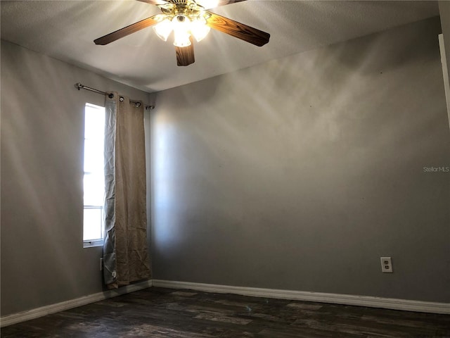 unfurnished room with plenty of natural light, ceiling fan, a textured ceiling, and dark hardwood / wood-style flooring