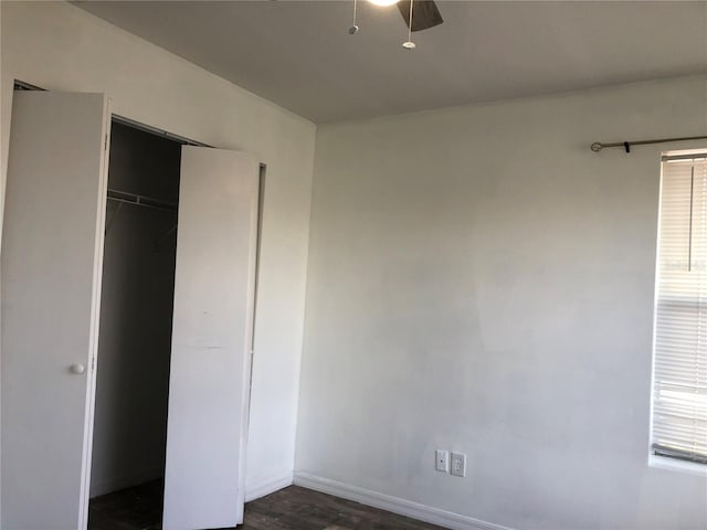 unfurnished bedroom featuring a closet, ceiling fan, and dark wood-type flooring