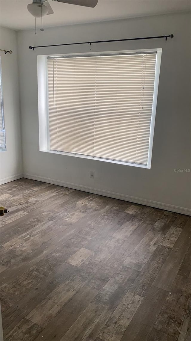 unfurnished room with dark wood-type flooring, ceiling fan, and a wealth of natural light