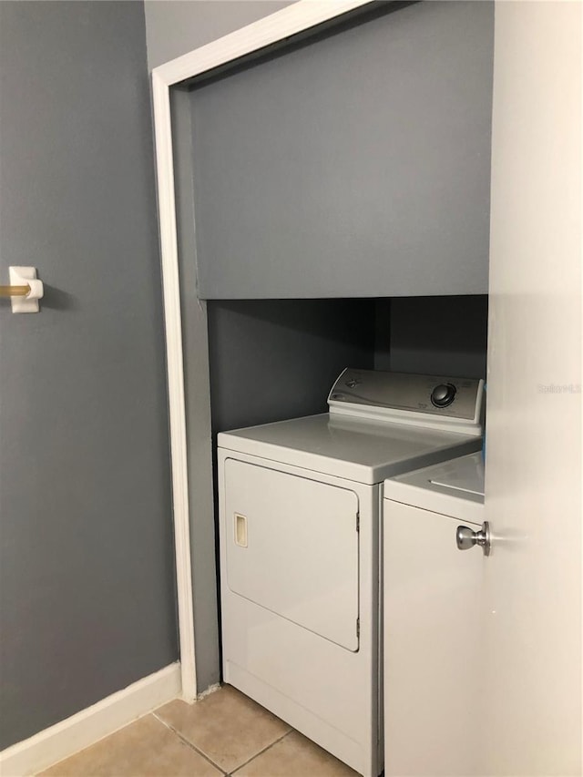 laundry room with independent washer and dryer and light tile patterned floors