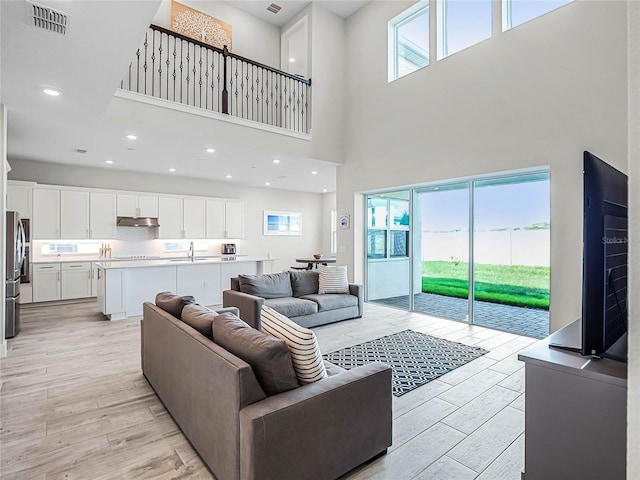 living room with a towering ceiling and sink