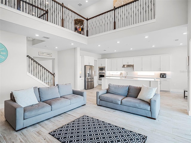 living room with a towering ceiling and sink