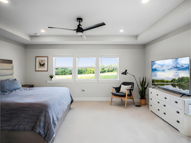 bedroom featuring a raised ceiling and ceiling fan