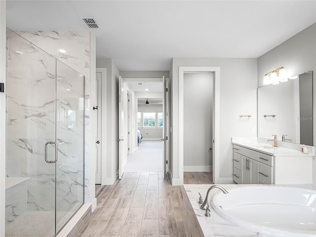 bathroom featuring vanity, hardwood / wood-style flooring, separate shower and tub, and ceiling fan