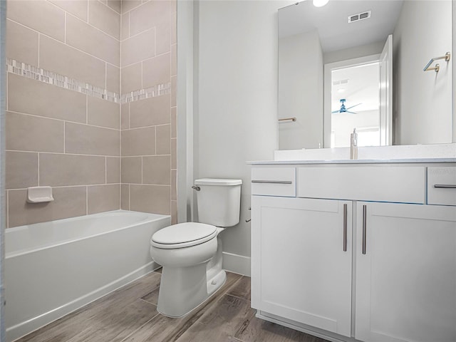 full bathroom with vanity, hardwood / wood-style flooring, toilet, and tiled shower / bath