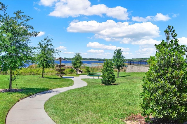 view of home's community with a water view and a lawn