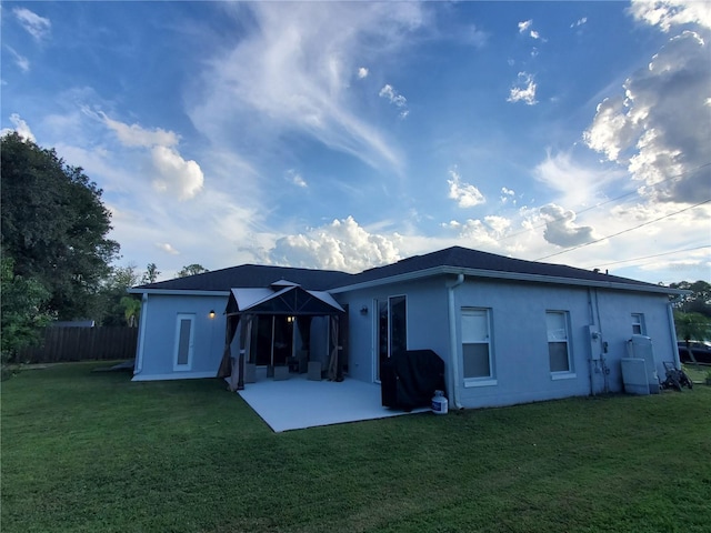 rear view of house with a lawn and a patio area