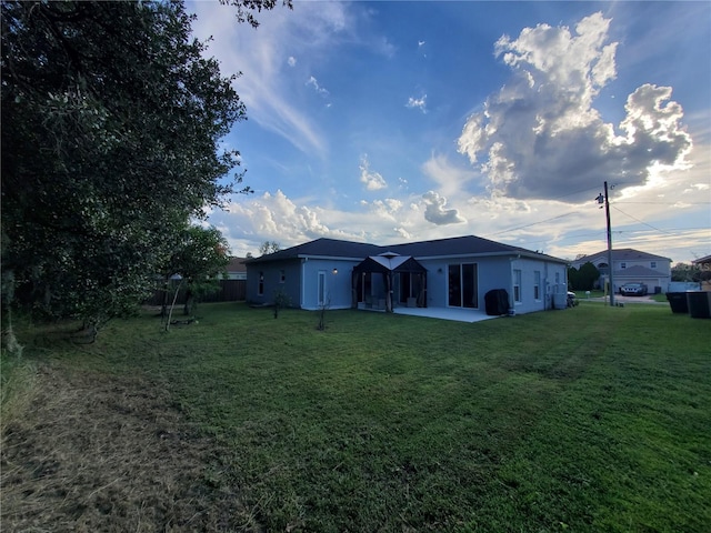 rear view of house with a patio area and a yard