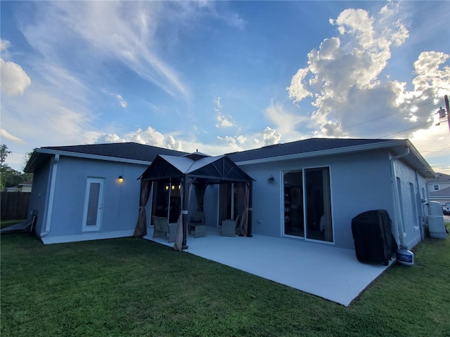 back of house with a sunroom, a patio area, and a yard