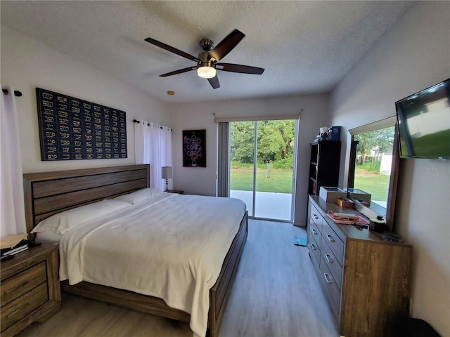 bedroom with ceiling fan, a textured ceiling, light hardwood / wood-style floors, and access to outside