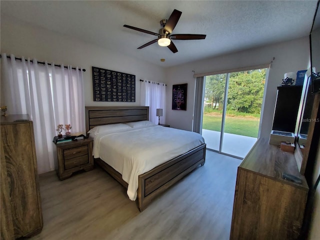 bedroom with light hardwood / wood-style flooring, ceiling fan, access to exterior, and a textured ceiling