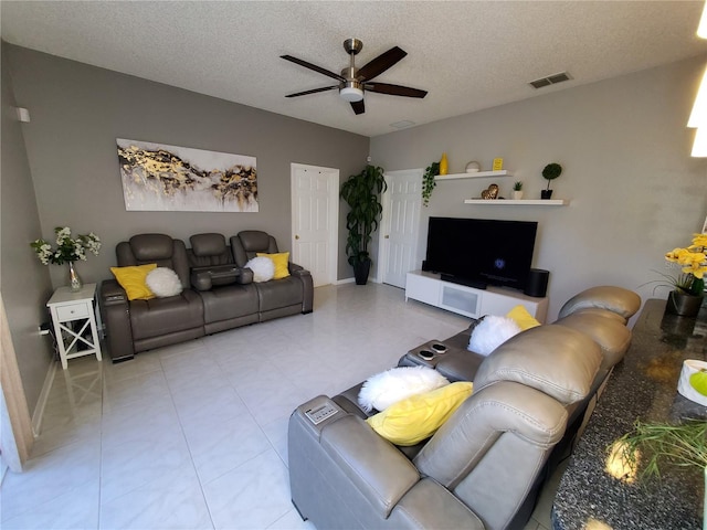 living room featuring a textured ceiling and ceiling fan