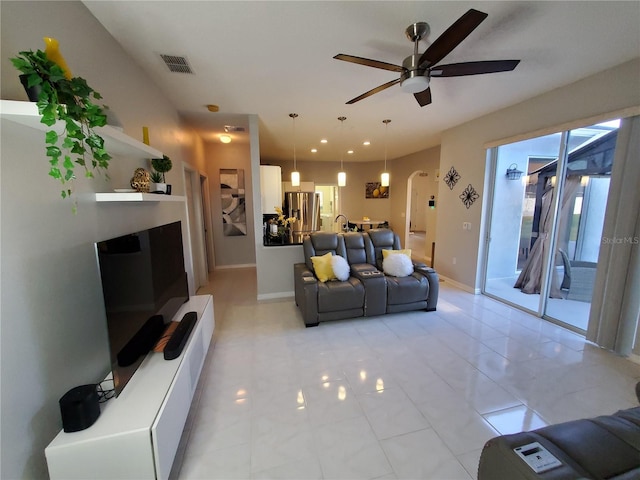 tiled living room with ceiling fan