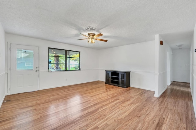 unfurnished living room with ceiling fan, a textured ceiling, and light hardwood / wood-style flooring