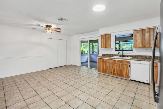 kitchen with light tile patterned floors, sink, white dishwasher, and ceiling fan