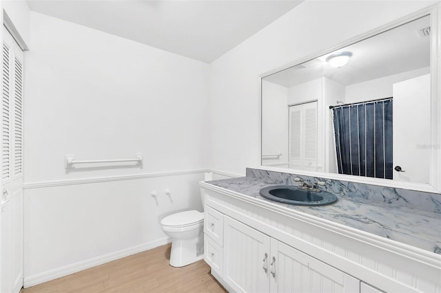 bathroom with vanity, toilet, and hardwood / wood-style flooring